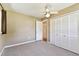 This bedroom features neutral carpeting, a ceiling fan, and closet with louvered doors at 5073 Lake Howell Rd, Winter Park, FL 32792