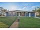 Charming blue single-story home with a well-manicured lawn and inviting front porch at 5073 Lake Howell Rd, Winter Park, FL 32792