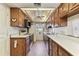 Narrow kitchen with wooden cabinets, white countertops and a ceiling fan above at 5073 Lake Howell Rd, Winter Park, FL 32792