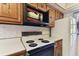 White appliances, wood cabinets and white countertop in this functional kitchen at 5073 Lake Howell Rd, Winter Park, FL 32792