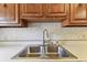 Close up of the double stainless steel sink, white counter top and faucet at 5073 Lake Howell Rd, Winter Park, FL 32792