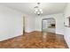 Open living room with hardwood floors and an arched entrance to another room with a fireplace at 5073 Lake Howell Rd, Winter Park, FL 32792