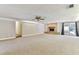 Bright living room features neutral carpet, a brick fireplace, and sliding glass doors to the pool at 5073 Lake Howell Rd, Winter Park, FL 32792