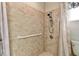 Updated tiled shower with handrails and shower head in a renovated bathroom at 5073 Lake Howell Rd, Winter Park, FL 32792