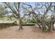 Spacious backyard with mature trees, offering shade and privacy in a natural setting at 5849 Groveline Dr, Orlando, FL 32810