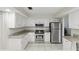 Well-lit kitchen with stainless steel appliances, white cabinetry, and granite countertops at 5849 Groveline Dr, Orlando, FL 32810