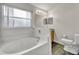 Bathroom with a soaking tub, a privacy window, neutral-toned walls, and a tiled floor at 609 Bluebill Ln, Kissimmee, FL 34759