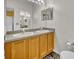 Bathroom featuring a double sink vanity with wood cabinetry and a large mirror at 609 Bluebill Ln, Kissimmee, FL 34759