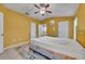 Sunny bedroom featuring a brass bed frame, neutral tile flooring, and white trim at 609 Bluebill Ln, Kissimmee, FL 34759