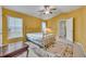 Bright bedroom with a brass bed frame, ceiling fan, and an en suite bathroom visible through the open door at 609 Bluebill Ln, Kissimmee, FL 34759