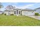 Charming single-story home with arched windows, light green exterior and attached two car garage at 609 Bluebill Ln, Kissimmee, FL 34759