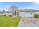 Charming single-story home with arched windows, light green exterior and attached two car garage at 609 Bluebill Ln, Kissimmee, FL 34759