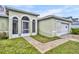 A close up of the front entrance with arched windows and a door with security system sign at 609 Bluebill Ln, Kissimmee, FL 34759