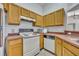 Galley kitchen featuring white appliances and wood cabinets at 609 Bluebill Ln, Kissimmee, FL 34759