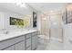 Modern bathroom featuring double sinks, sleek gray cabinetry, and a glass-enclosed shower at 6406 Tabebuia Pkwy, Winter Garden, FL 34787