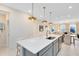 Kitchen island with modern pendant lighting, stainless steel sink and appliances at 6406 Tabebuia Pkwy, Winter Garden, FL 34787