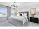 This primary bedroom features a soothing color palette, contemporary lighting, and large windows at 6406 Tabebuia Pkwy, Winter Garden, FL 34787