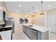 Modern kitchen with stainless steel appliances, quartz countertop island with seating, and ample cabinet space at 6412 Tabebuia Pkwy, Winter Garden, FL 34787