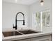 Close-up of kitchen island featuring a modern pull-down faucet and a stainless steel sink at 6430 Sw 145Th Ln, Ocala, FL 34473