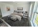 Bright main bedroom with a decorative rug, a bench, and a pair of windows at 6430 Sw 145Th Ln, Ocala, FL 34473