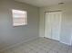 Bright bedroom with a window and a closet; neutral walls and a tiled floor create a clean, minimalist space at 709 Michigan Ct # 4, St Cloud, FL 34769