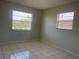 This bedroom features neutral tile, 2 windows, and ample lighting at 709 Michigan Ct # 4, St Cloud, FL 34769