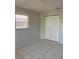 Neutrally painted bedroom with a tiled floor and a closet, lit by a window with blinds at 709 Michigan Ct # 4, St Cloud, FL 34769