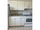 Kitchen featuring white appliances, white cabinets and tile floors at 709 Michigan Ct # 4, St Cloud, FL 34769