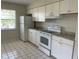 Bright kitchen with white appliances, white tile flooring, and grey countertops at 709 Michigan Ct # 4, St Cloud, FL 34769