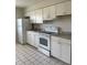 Kitchen featuring white appliances, white cabinets and tile floors at 709 Michigan Ct # 4, St Cloud, FL 34769