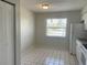 Bright kitchen with white appliances, tile flooring, a closet, and a window view at 709 Michigan Ct # 4, St Cloud, FL 34769