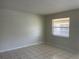 An empty living room featuring tile floors, neutral walls and a bright window at 709 Michigan Ct # 4, St Cloud, FL 34769