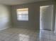 A bright and airy living room with tile floors, neutral paint, an entry door, and a window at 709 Michigan Ct # 4, St Cloud, FL 34769