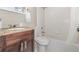 Bathroom with a dark wood vanity, granite countertop, and a shower-tub combo at 8121 Deville Ct, Orlando, FL 32817