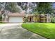 Inviting single-story home with a well-manicured lawn, attached garage, and mature landscaping at 8121 Deville Ct, Orlando, FL 32817