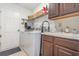 Well-equipped laundry room with modern washer and dryer, utility sink, and storage cabinets at 8121 Deville Ct, Orlando, FL 32817