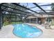 Sparkling pool with screened enclosure surrounded by mature trees, a grill and chairs for entertaining at 8121 Deville Ct, Orlando, FL 32817