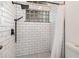 Bright shower with subway tile, glass block window, and black fixtures at 8121 Deville Ct, Orlando, FL 32817