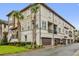 New townhomes with multiple car garages, beige and white paint, tropical landscaping and a shared front entrance at 1012 Parma Cir, Lake Mary, FL 32746