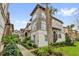 Beautiful townhome exterior with manicured lawn, tropical landscaping and a sidewalk out front at 1012 Parma Cir, Lake Mary, FL 32746