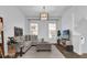 Inviting living room featuring a gray sofa, a patterned ottoman, modern decor, and ample natural light at 1012 Parma Cir, Lake Mary, FL 32746