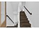 Elegant staircase featuring dark wood steps, crisp white risers, and a sleek black metal railing at 1012 Parma Cir, Lake Mary, FL 32746