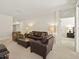Spacious living room featuring a comfortable leather sofa and a view into the main bedroom at 1205 Bella Rose Ct, Davenport, FL 33896