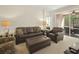 Inviting living room with comfortable leather furniture and sliding glass doors to the outside at 1205 Bella Rose Ct, Davenport, FL 33896