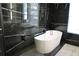 Modern bathroom highlighting a freestanding tub, black marble accent wall, and glass shower enclosure at 13413 Hopkinton Ct, Windermere, FL 34786