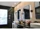 Modern bathroom featuring a double vanity with sleek countertops, decorative mirrors, and elegant black marble accents at 13413 Hopkinton Ct, Windermere, FL 34786