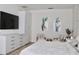 Bright bedroom with TV, soft bedding, and art, featuring a dresser and comfortable seating, promoting relaxation at 13413 Hopkinton Ct, Windermere, FL 34786