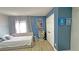 Bedroom featuring a light beige bed, blue walls, and a window with gray curtains at 13413 Hopkinton Ct, Windermere, FL 34786
