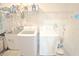 Bright laundry room with washer, dryer, utility sink, and shelving for convenient storage at 13413 Hopkinton Ct, Windermere, FL 34786