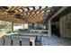 Outdoor kitchen with covered pergola, built-in grill, dining area, and durable flooring at 13413 Hopkinton Ct, Windermere, FL 34786